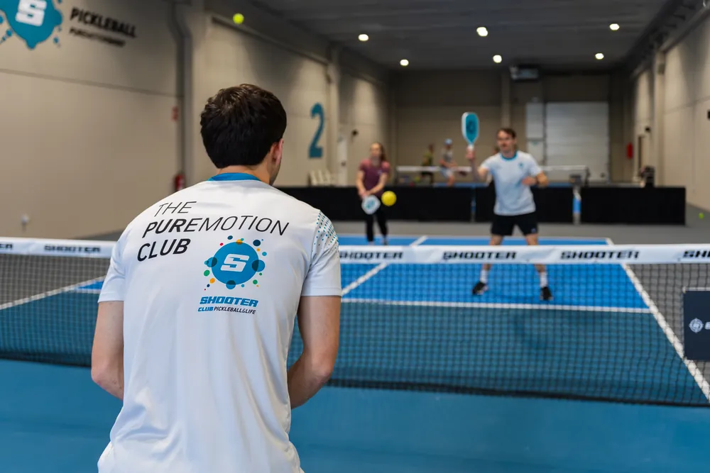 Jugador de pickleball a la xarxa mentre es disputa un punt